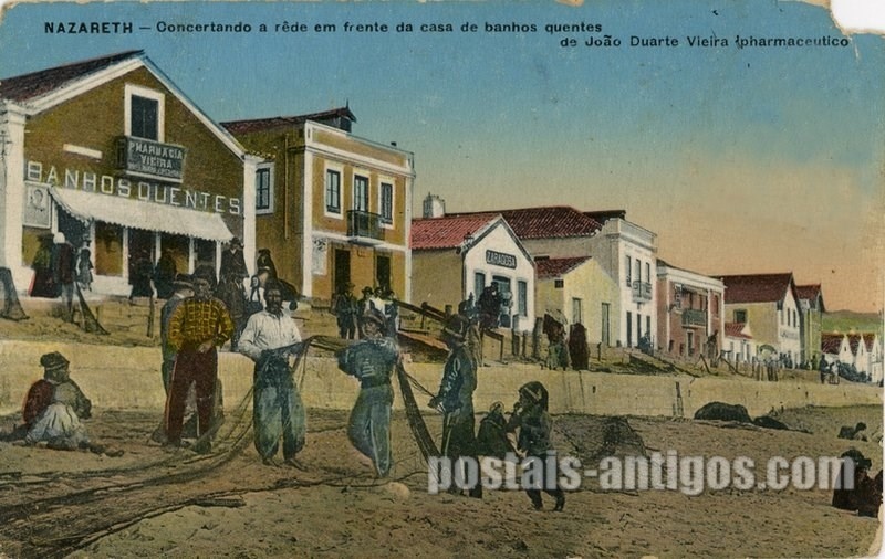 Bilhete postal ilustrado de Nazaré, concertando a rêde ​em frente da casa de banhos | Portugal em postais antigos